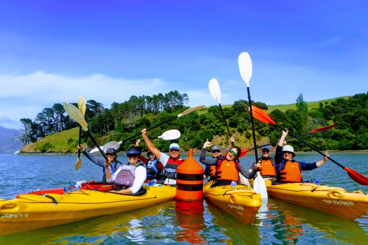 a group of people riding on the back of a boat in the water